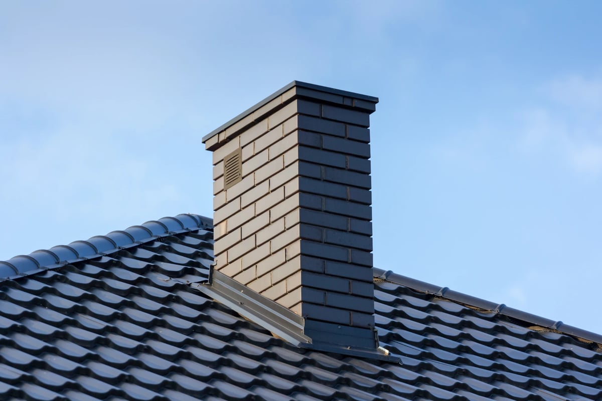 Brick chimney on a gray roof
