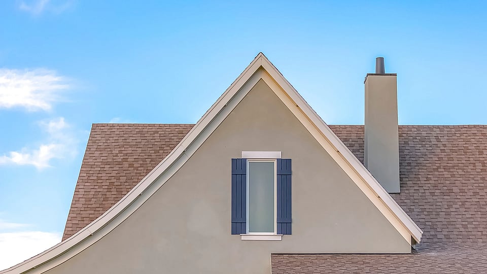 Adobe Stock image of a chimney chase with a cover and flue pipe.