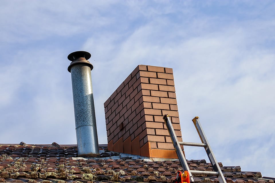Adobe stock image of a metal chimney next to a masonry chimney.