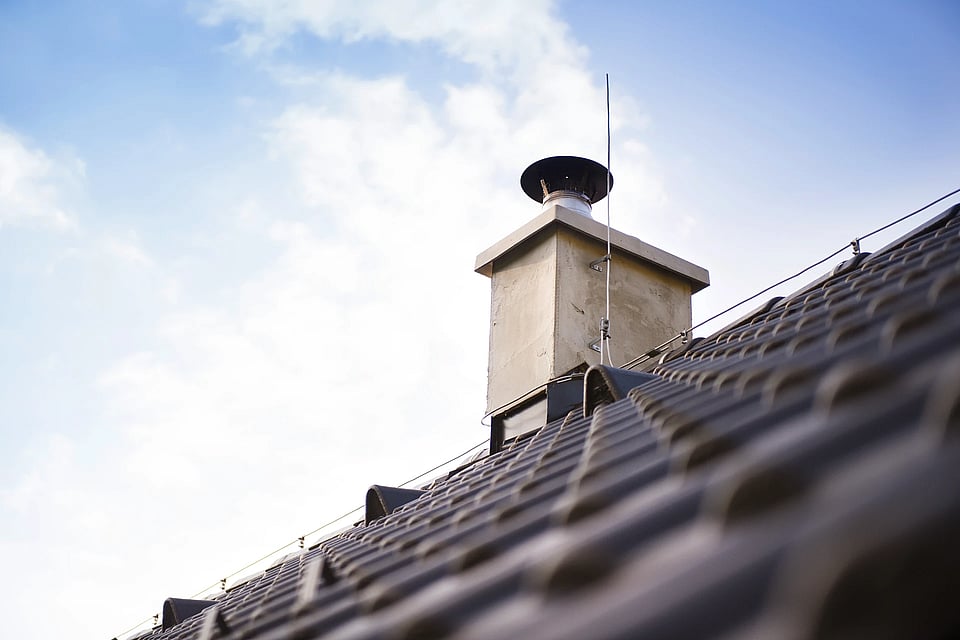 Adobe Stock image of a prefab chimney with a chase cover and cap.