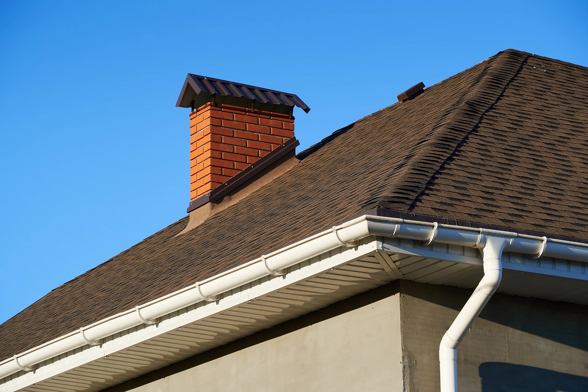 Red brick chimney with a black chimney cap