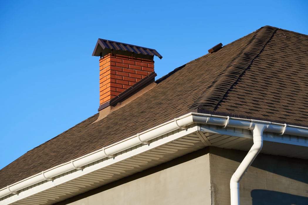Red brick chimney with a black cap