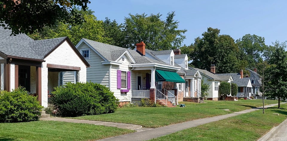 Adobe Stock image of houses with chimneys on a street with a sidewalk.