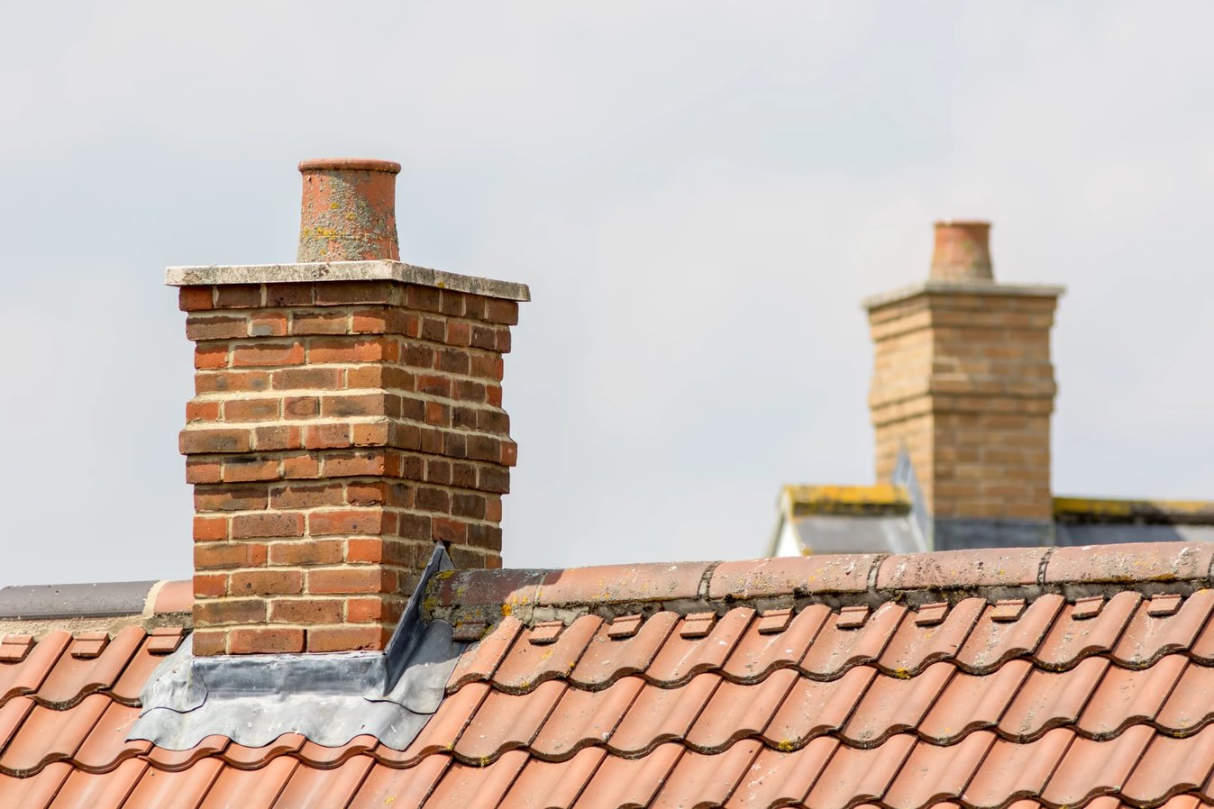 Adobe Stock image of two masonry chimneys on two different roofs
