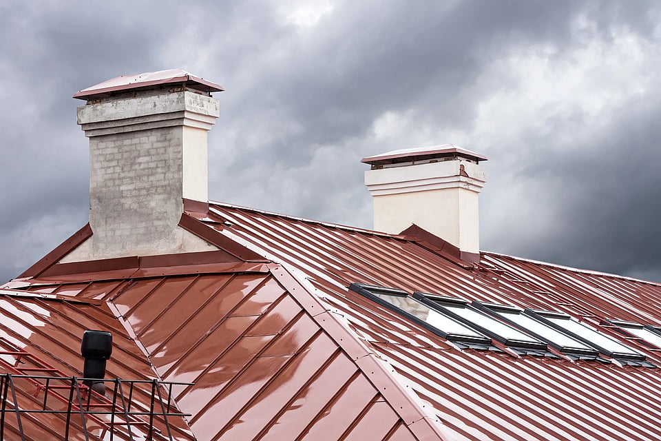 Adobe Stock image of two white brick chimneys against a cloudy rainy sky.