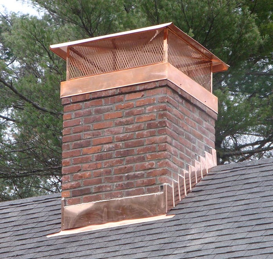 Original image from Alpine Chimney Sweeps of a masonry chimney with a copper chimney cap.