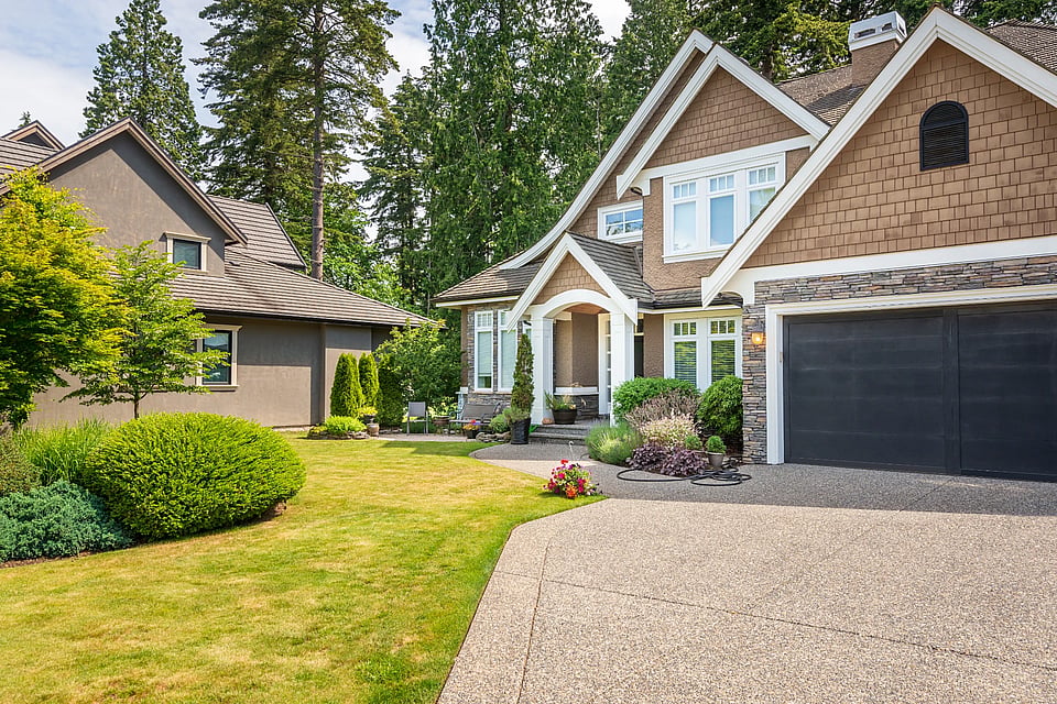 A home with a big yard and driveway.