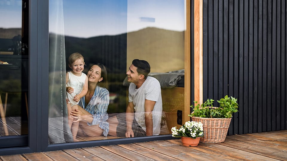 Adobe Stock image of a family looking into their yard from a sliding glass door.