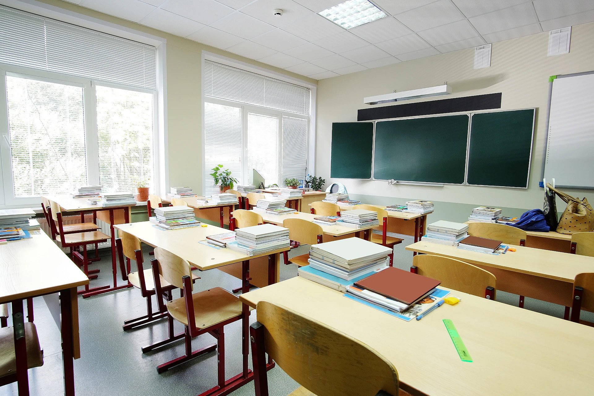 Adobe Stock image of a school classroom with desks and a chalkboard.