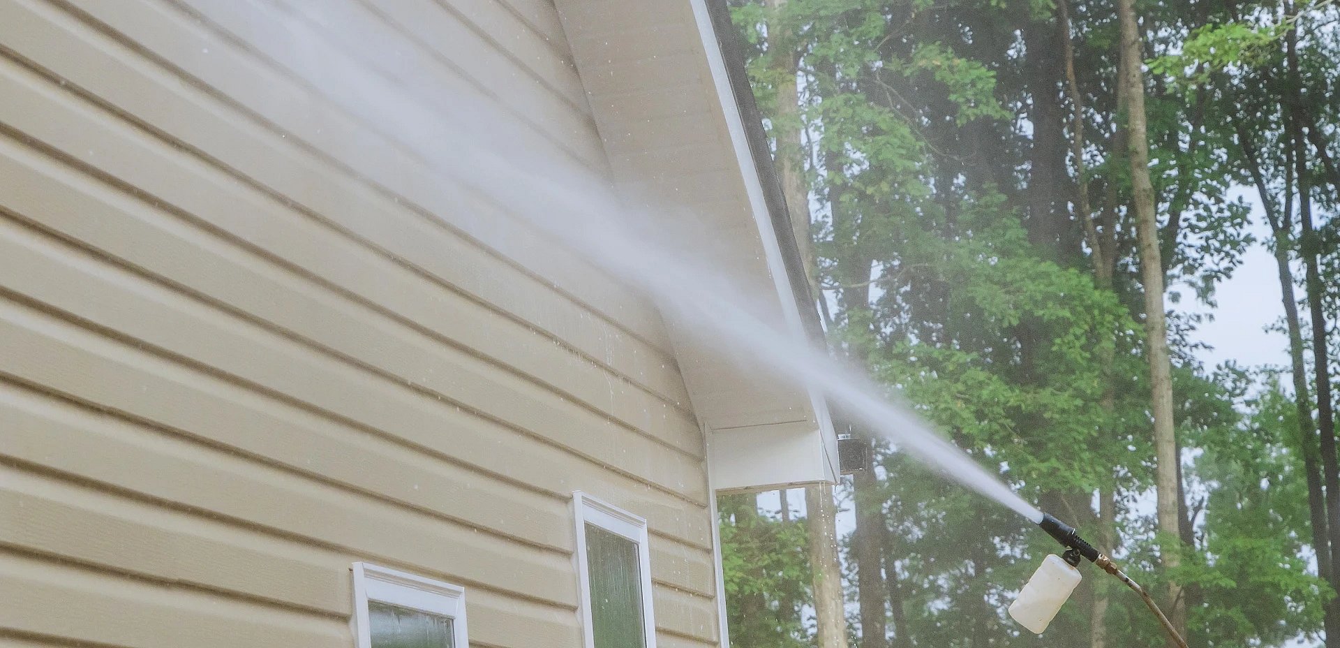 Adobe Stock image of a yellow house being soft washed.
