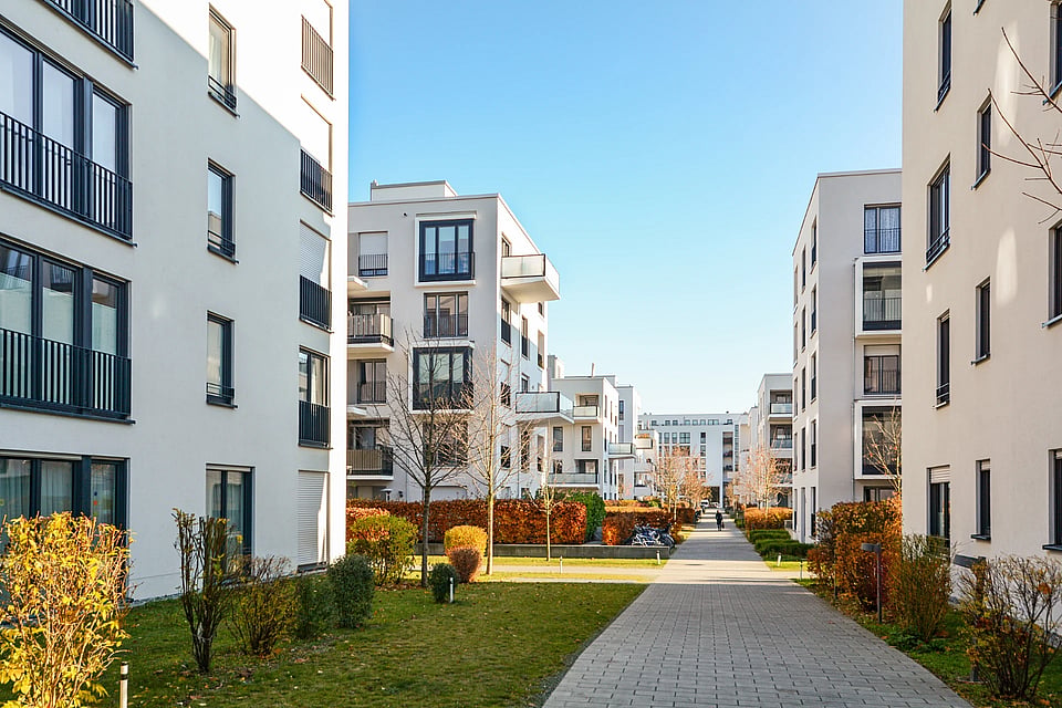 Adobe Stock image of apartment complexes and a sidewalk.