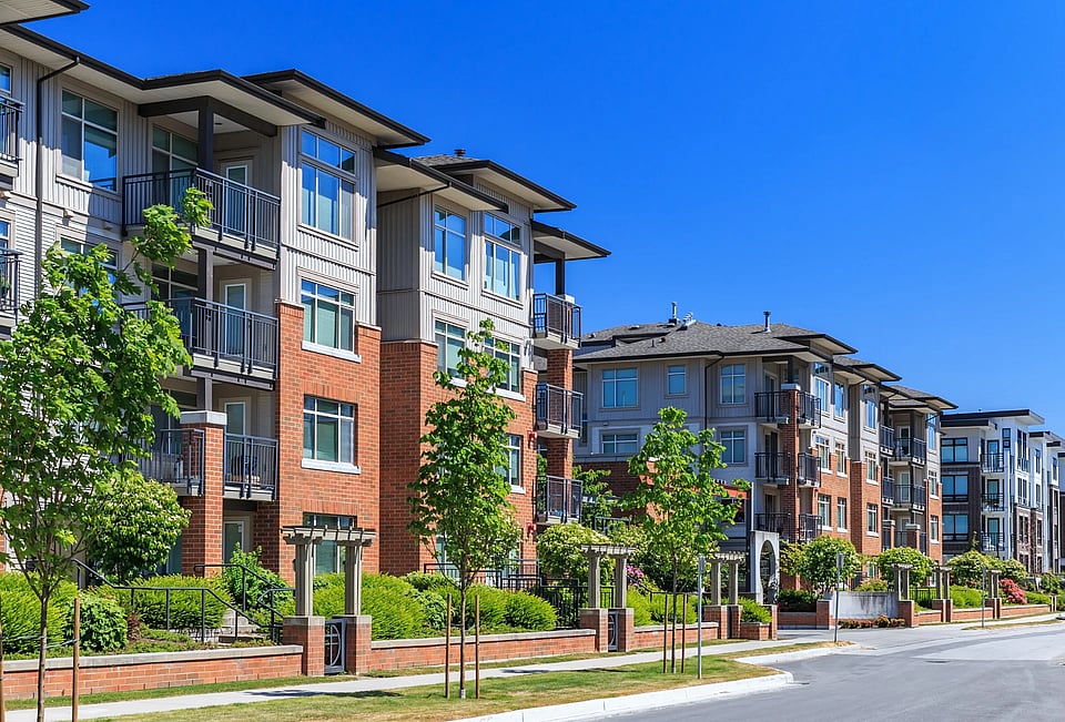 Adobe stock image of brown apartment complexes with trees.