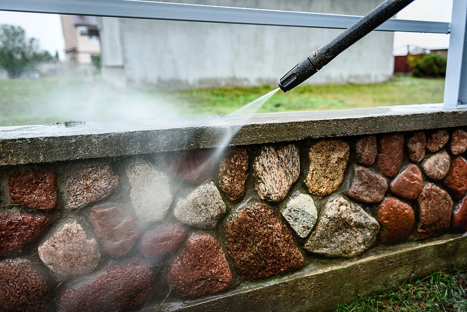 Adobe stock image of soft washing a stone wall.