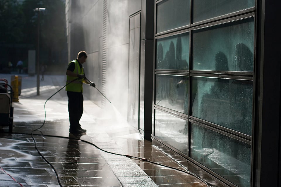Adobe Stock image of someone washing the outside of a business.