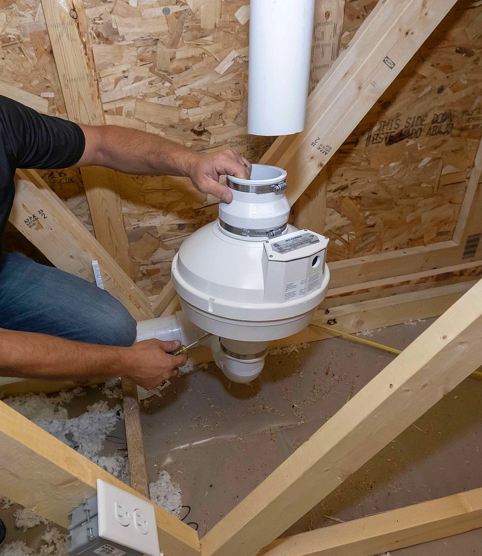 Image of a radon fan installed in a basement area.