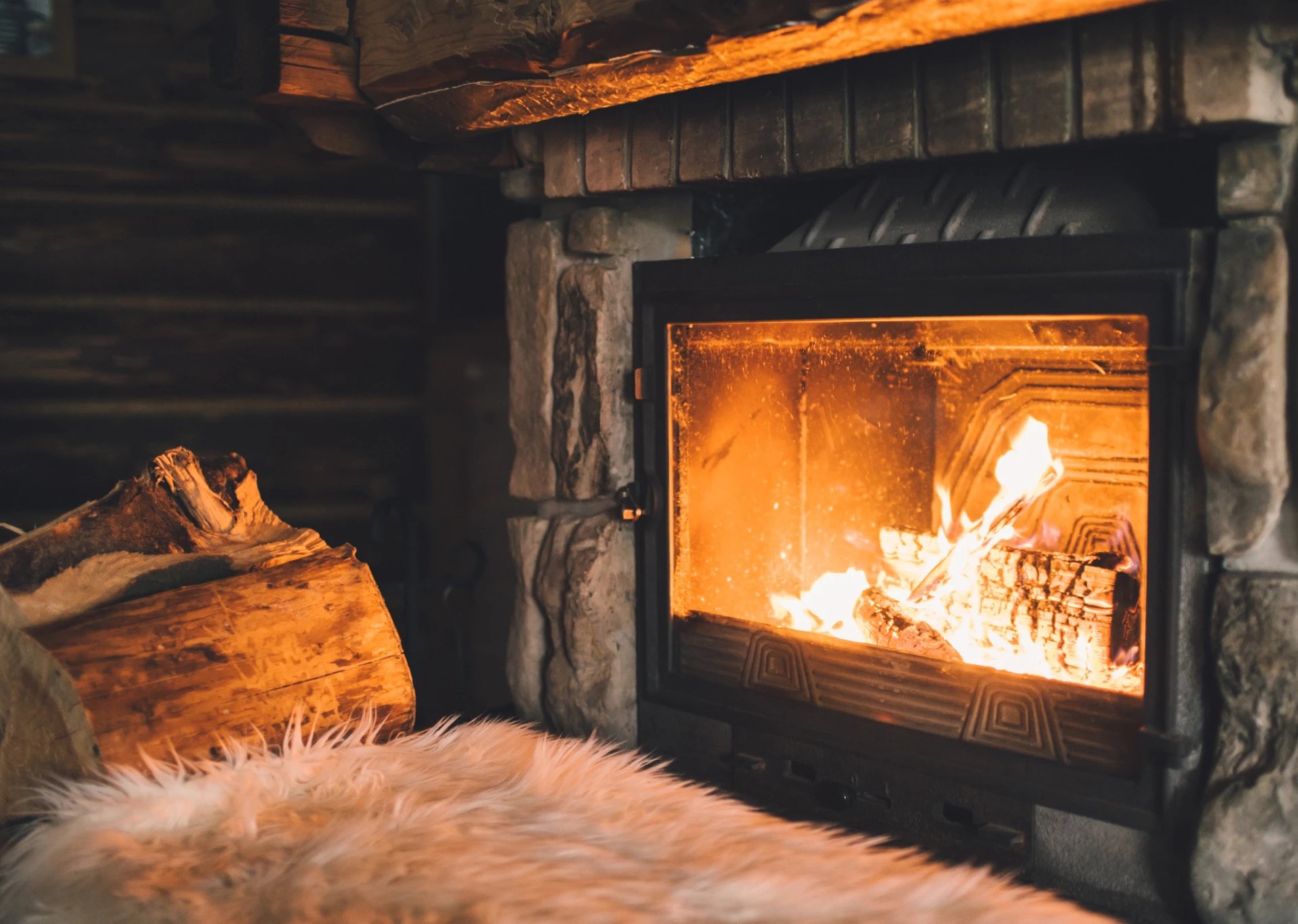Adobe Stock image of a fireplace insert with a wood pile next to it