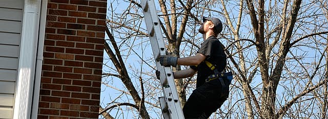 Chimney inspection technician on ladder