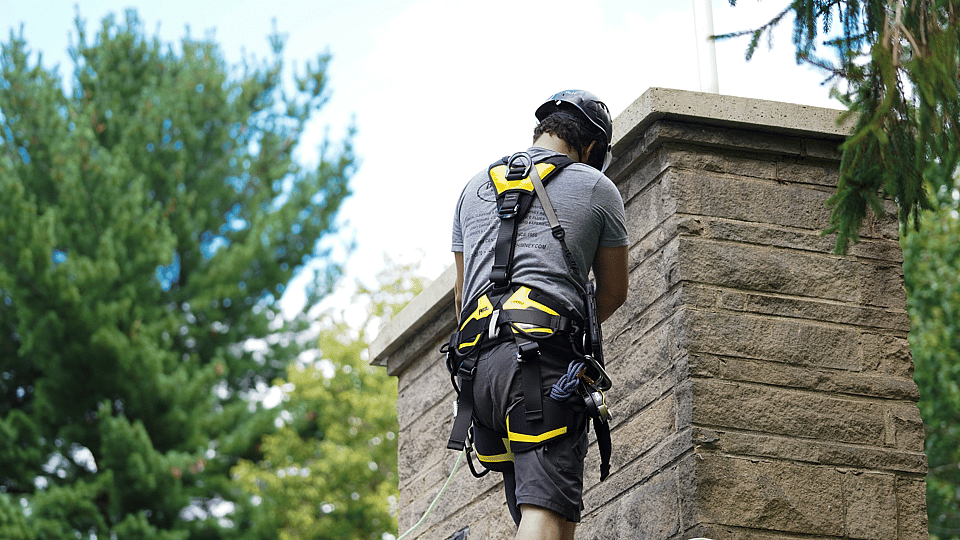 Professional chimney sweeping service cleaning a residential chimney