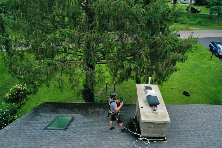 Blackburns employee inspecting a masonry chimney with proper harnesses