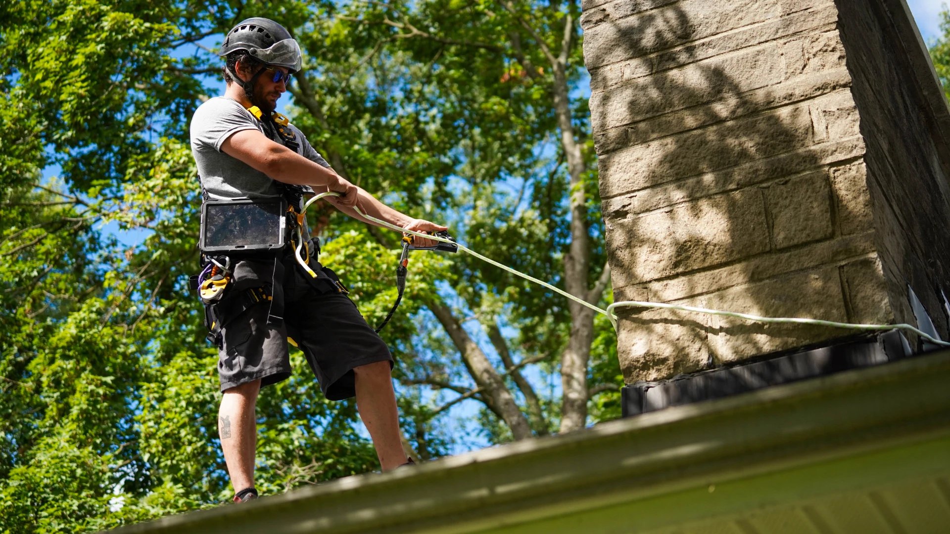 Original image of a Blackburns employee roping off a masonry chimney.