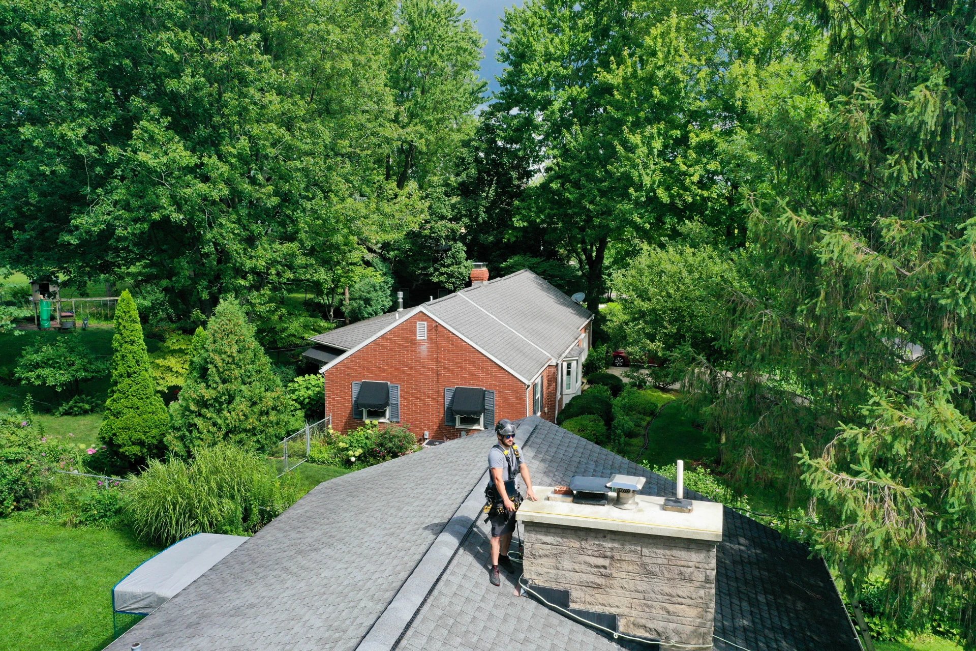 Original image of a Blackburns Chimney employee observing a chimney cap.