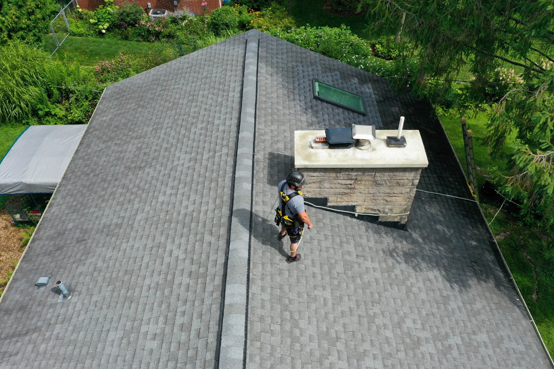 Blackburns Chimney Services employee on a rooftop examining a chimney cap installation in Columbus, OH