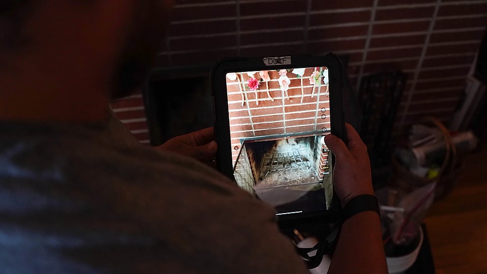 Original photo of a Blackburns employee examining a fireplace