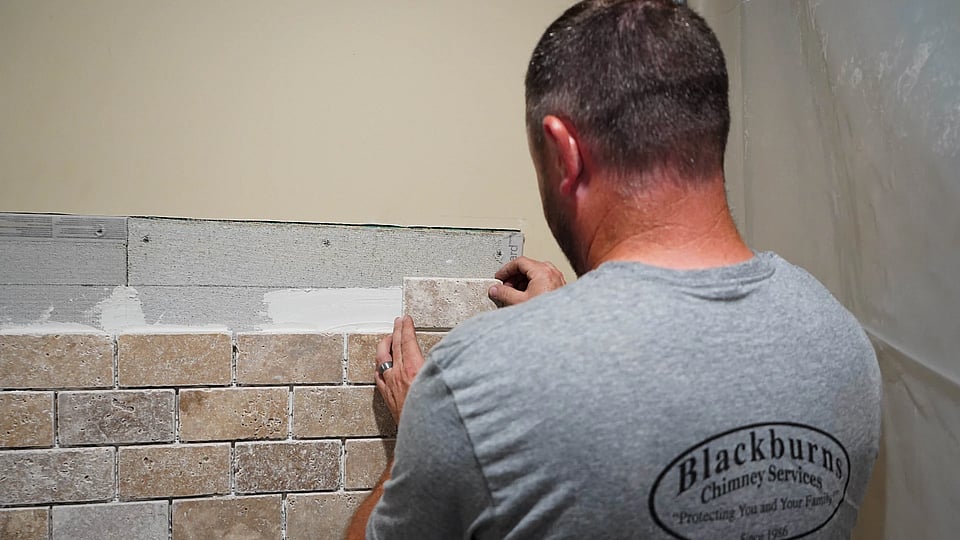 Original photo of a Blackburns employee installing a new fireplace surround.
