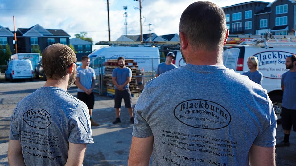 Original photo of Blackburns employees standing in a circle for a meeting.