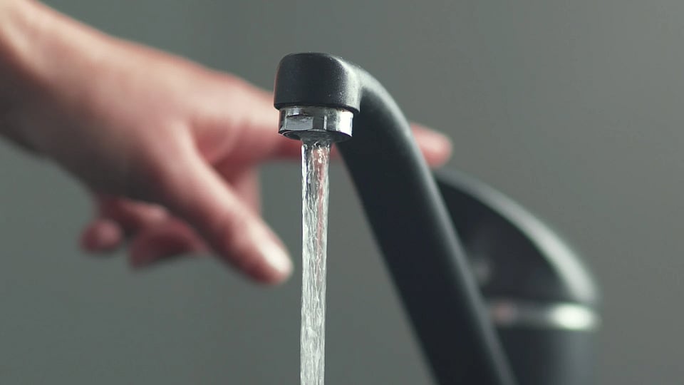 A black faucet with water coming out of it