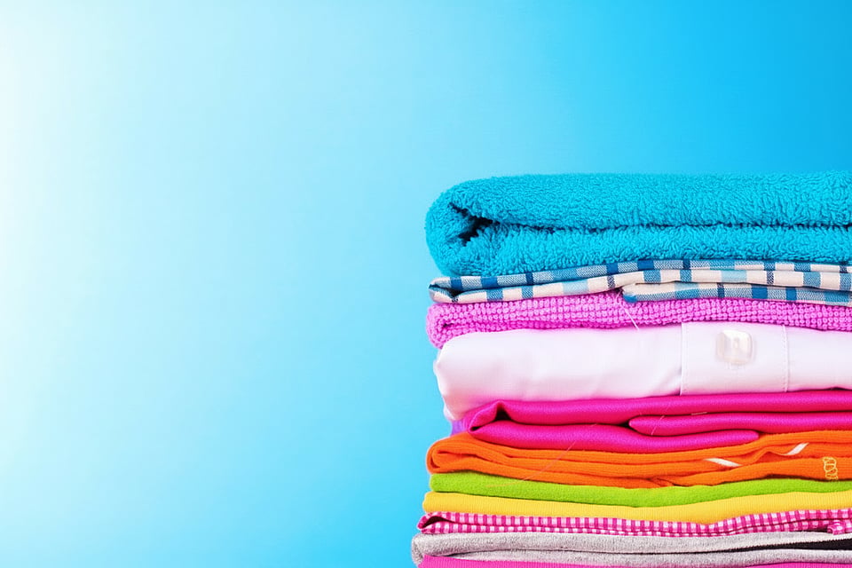A stack of folded clothes, all of which are brightly colored.