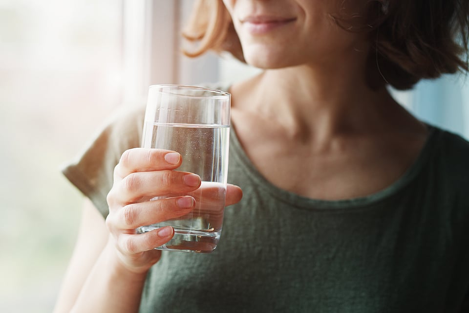 Woman drinking a glass of clear water