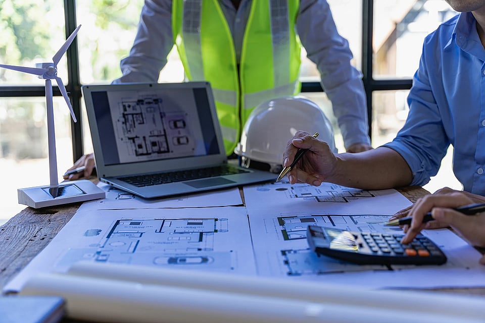 Environmental contractors making plans on blueprints.