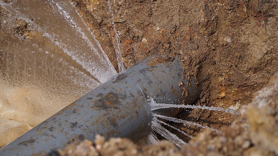 Adobe Stock image of a burst well pipe with water spraying out.