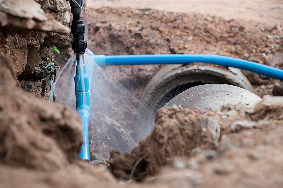 Adobe Stock image of a large plumbing pipe spraying water.