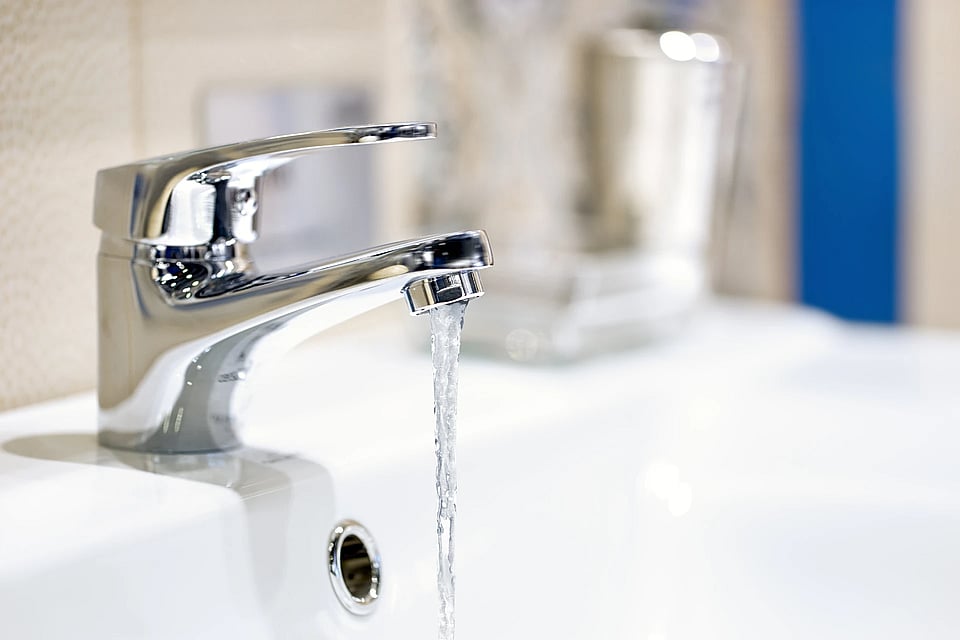 Adobe Stock image of a sink faucet running water.