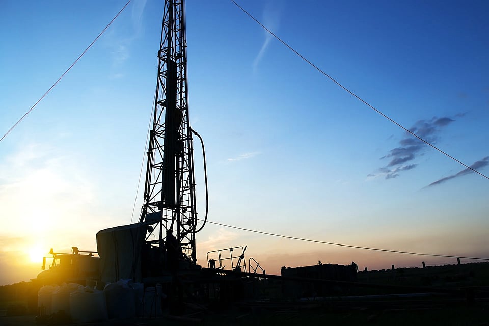 Adobe Stock image of a well system silhoutted in the sky.