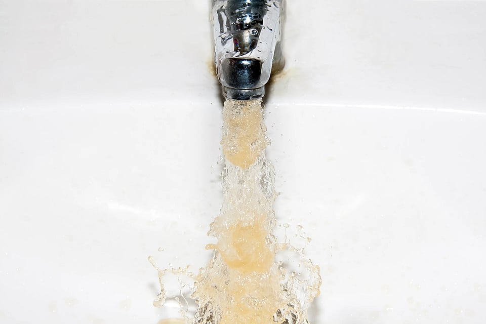 Adobe Stock image of discolored water coming out of a sink.