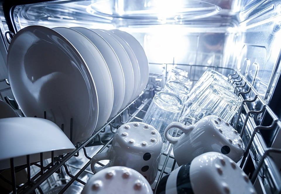 Adobe Stock image of dishes on a dishwasher rack.