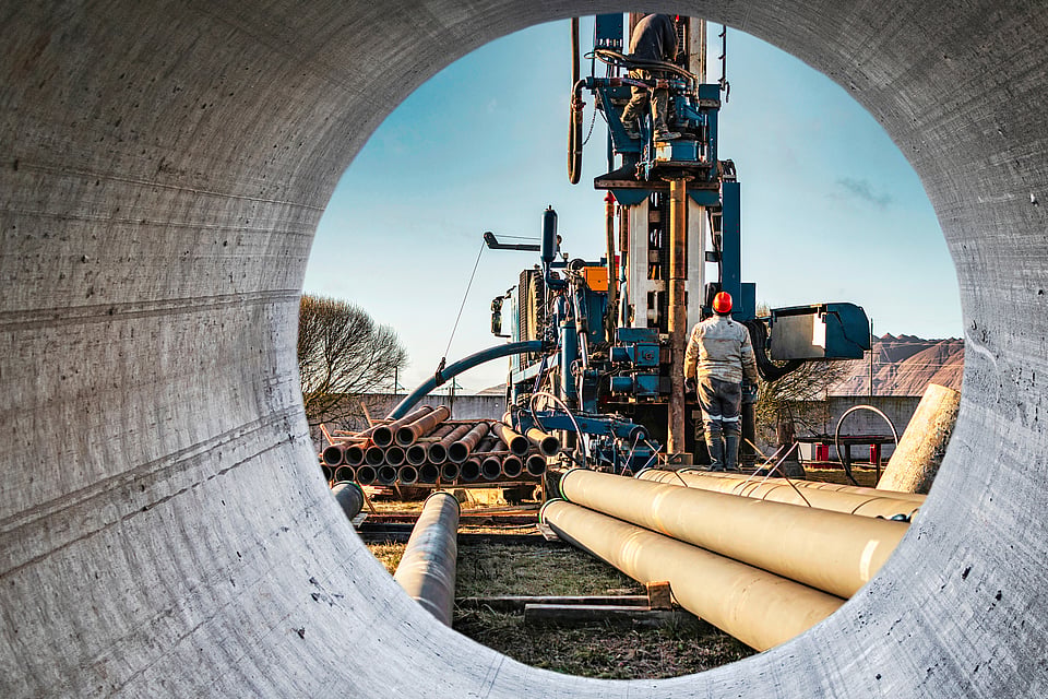 A well rigging rib seen through a large pipe.