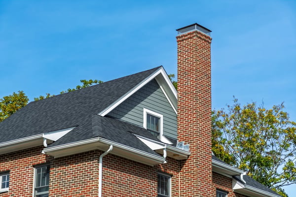Tall masonry chimney with a metal cap
