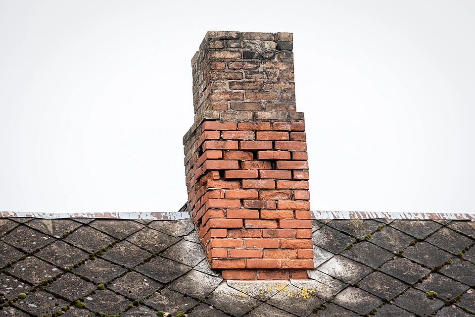 Adobe Stock image of a broken down masonry chimney that needs repair work.