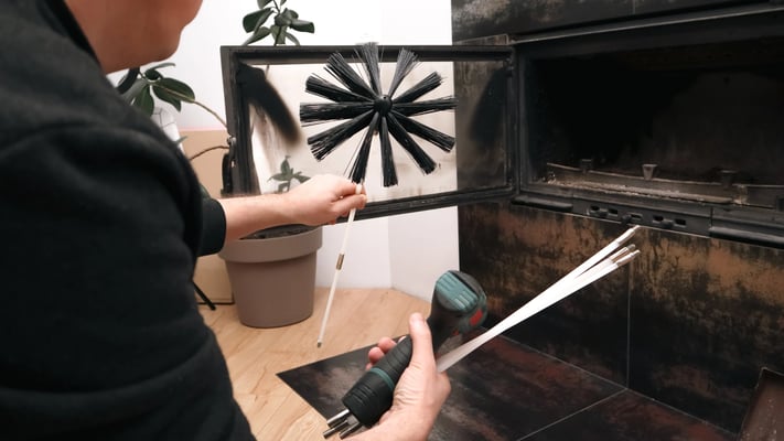 Chimney sweep holding fireplace tools