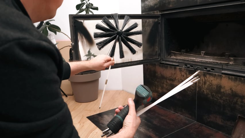 Adobe Stock image of a chimney sweep holding fireplace tools