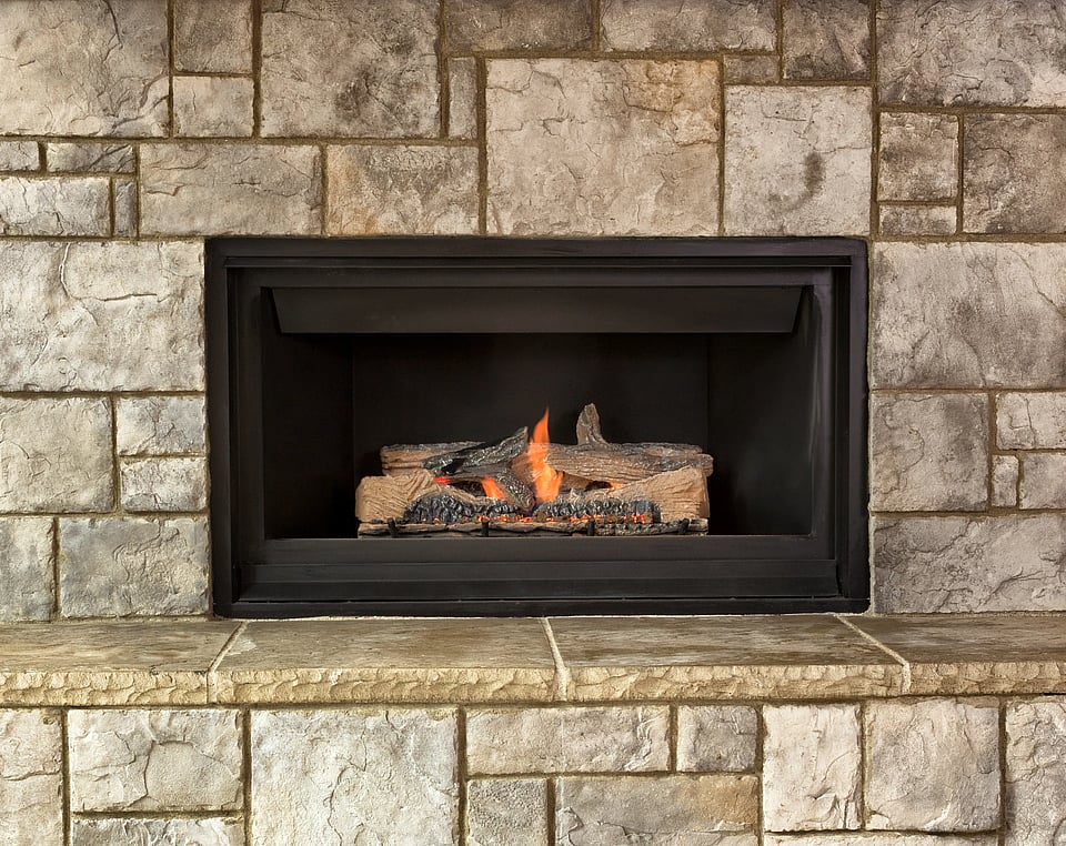 Adobe stock image of a gas fireplace with a brick surround.
