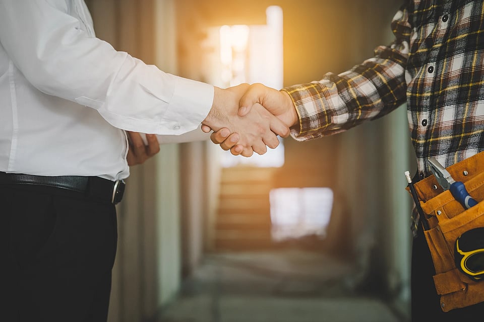 Adobe Stock image of a homeowner and service work shaking hands.