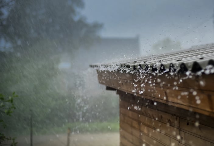 Adobe Stock image of rain coming off of a roof.