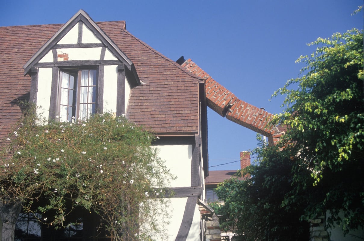 Adobe stock image of a brick chimney that has collapsed on a house.