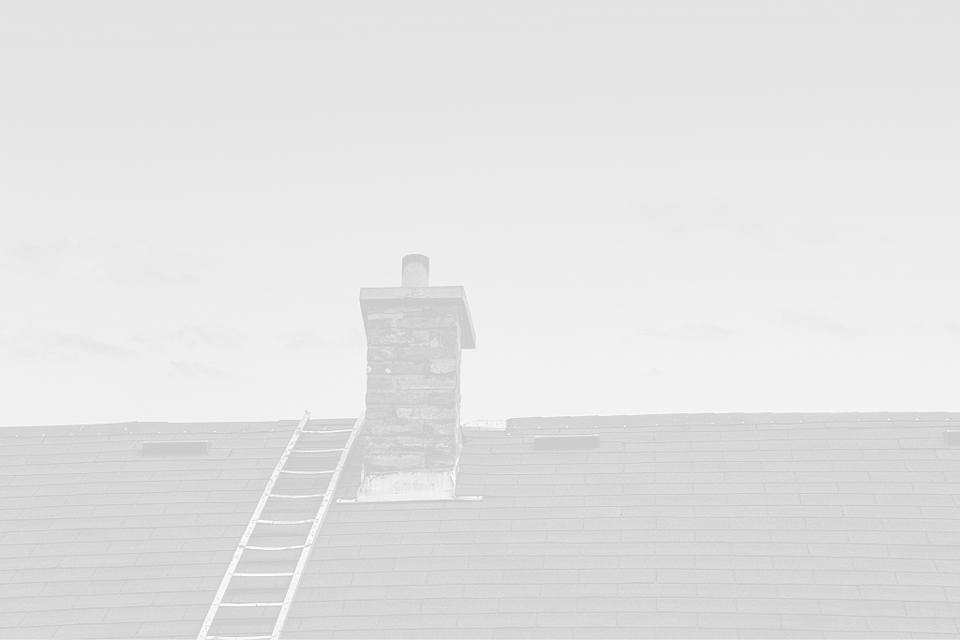 Chimney sweep on a ladder performing a professional chimney inspection on a residential rooftop