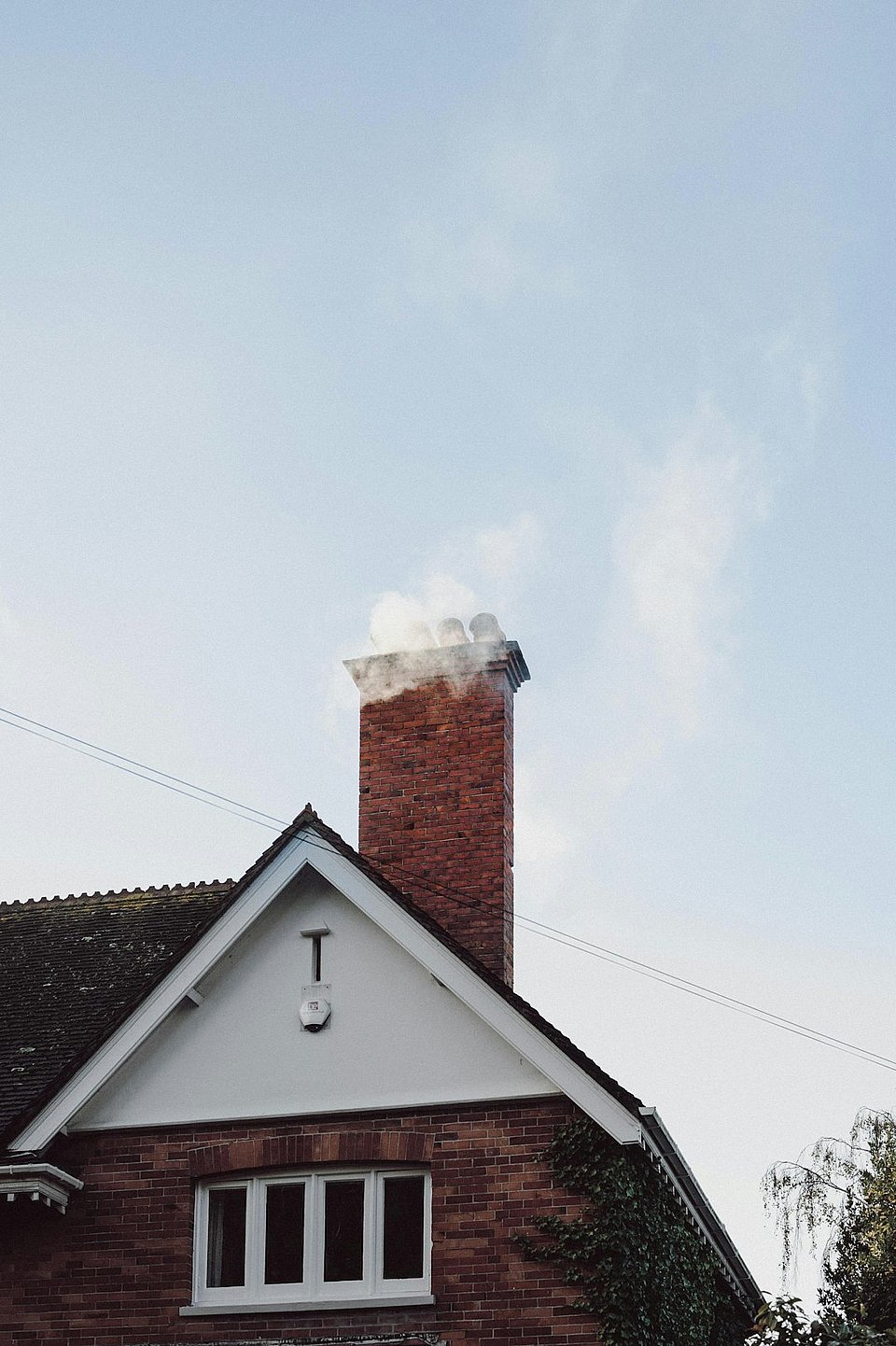 Chimney sweep technician performing annual chimney service